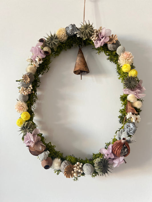 Ovaler Kranz aus Trockenblumen & stabilisiertem Moos mit Beeren, Kapseln & handgefertigter Glocke